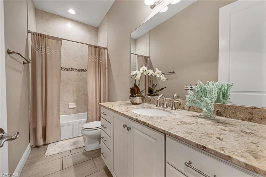 4741 Formosa Drive Naples, FL 34119 - Photo 7 of 18 a bathroom with a granite countertop sink a toilet and shower