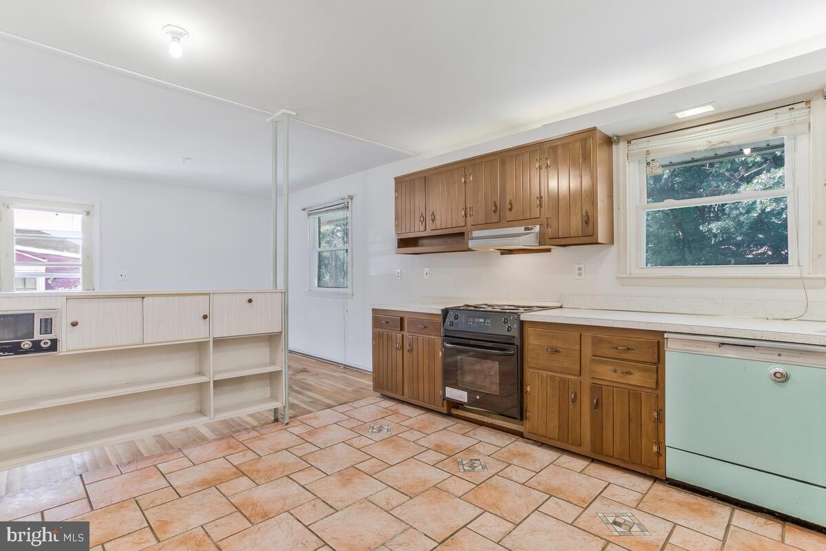 12412 Palermo Drive Silver Spring, MD 20904 - Photo 17 of 43 a kitchen with granite countertop a stove a sink and a microwave