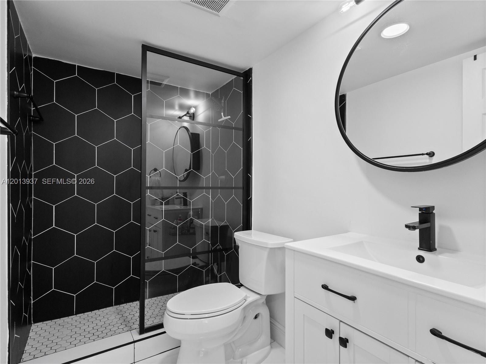 7487 Southwest 82nd Street, Unit C208 Miami, FL 33143 - Photo 18 of 28 a bathroom with a sink toilet and a mirror