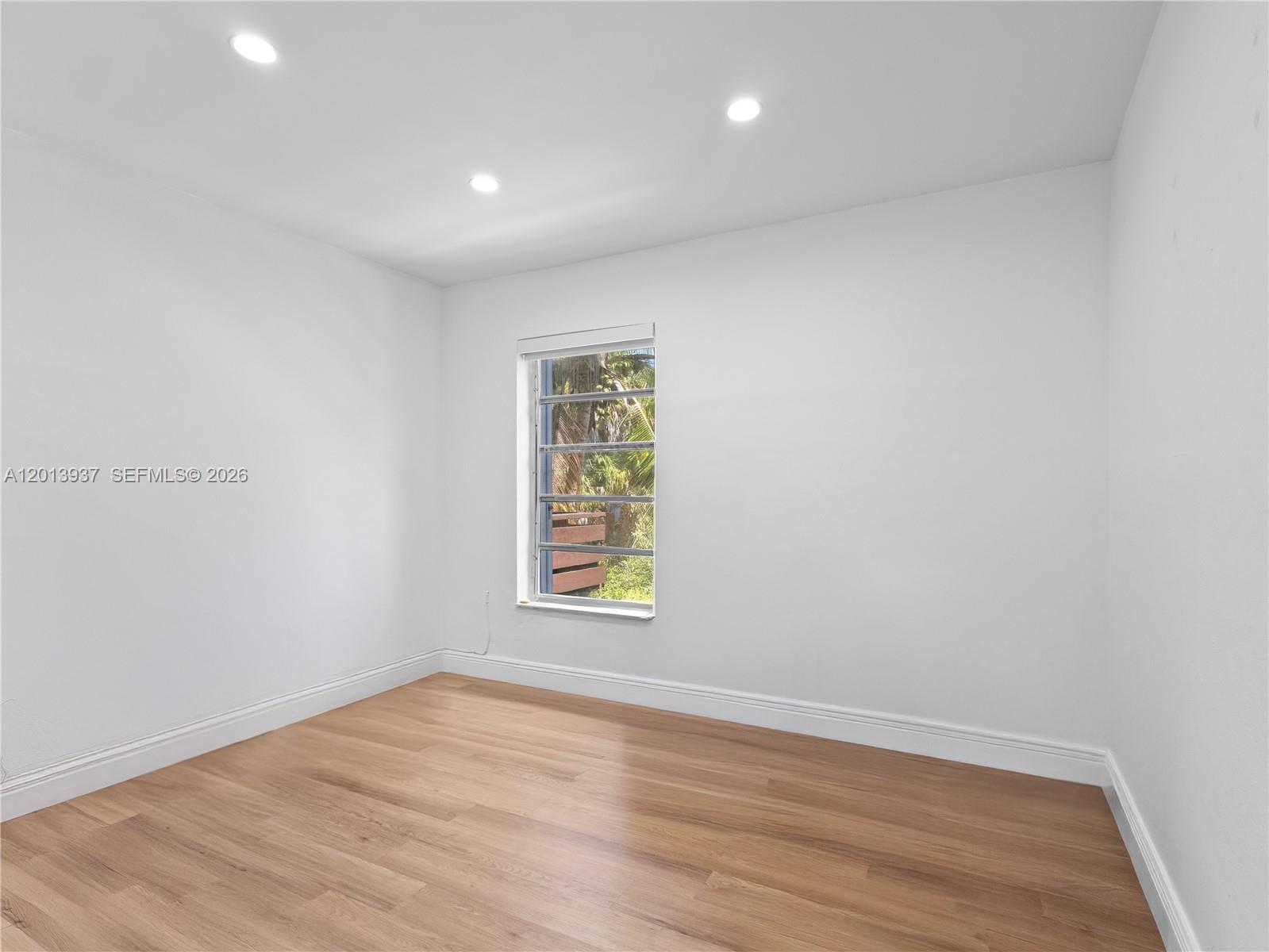 7487 Southwest 82nd Street, Unit C208 Miami, FL 33143 - Photo 19 of 28 an empty room with wooden floor and windows