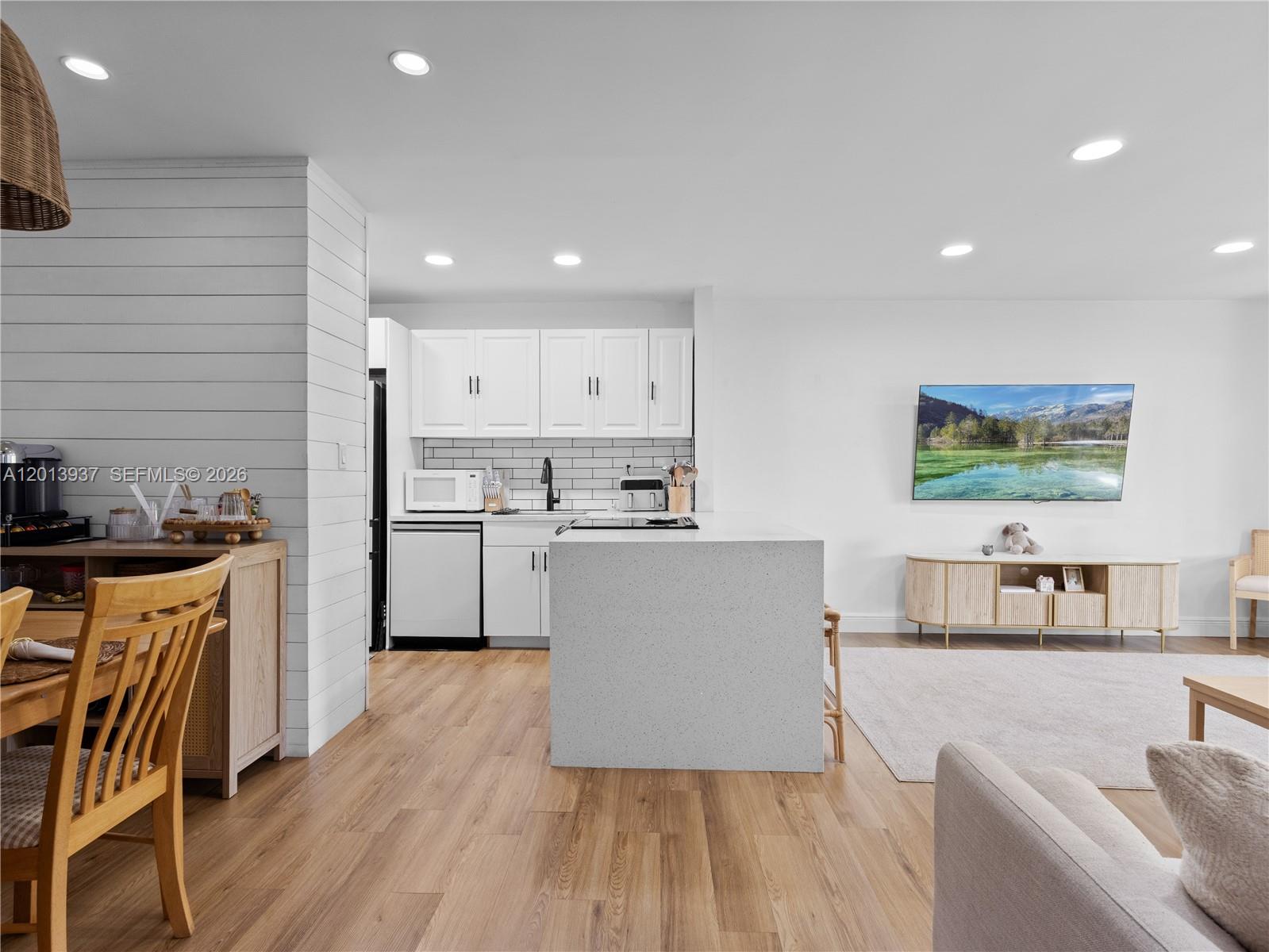 7487 Southwest 82nd Street, Unit C208 Miami, FL 33143 - Photo 6 of 28 a kitchen with stainless steel appliances granite countertop a refrigerator a stove top oven a sink dishwasher and white cabinets with wooden floor