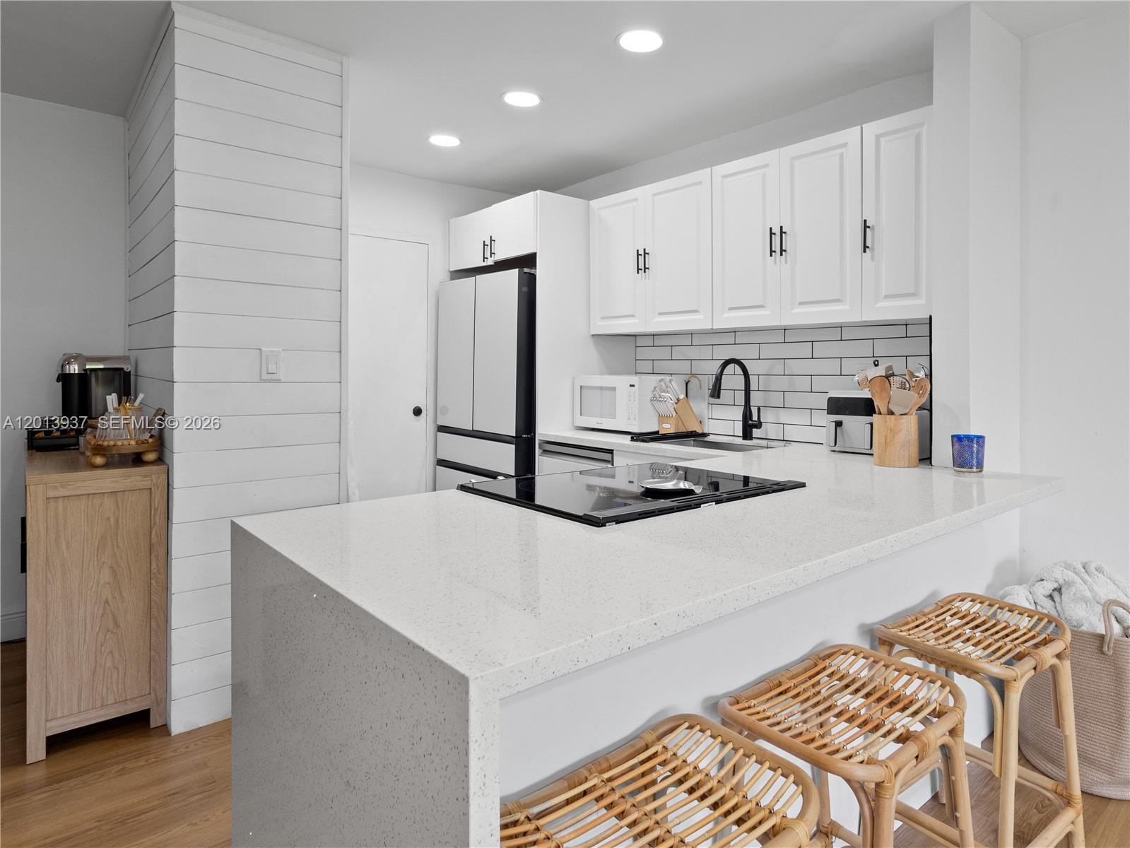 7487 Southwest 82nd Street, Unit C208 Miami, FL 33143 - Photo 9 of 28 a kitchen with kitchen island a sink appliances and cabinets