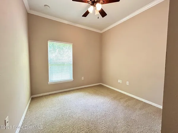 an empty room with a window and a fan