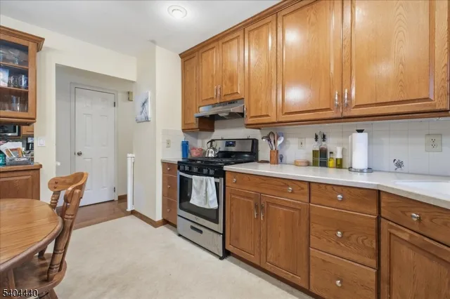a kitchen with stainless steel appliances granite countertop a stove a sink cabinets and a refrigerator