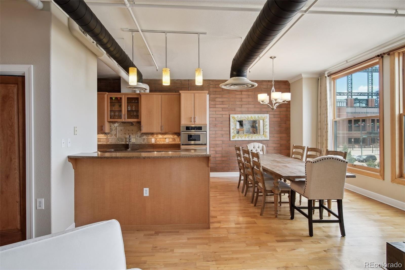 2245 Blake Street, Unit C Denver, CO 80205 - Photo 13 of 40 a living room with stainless steel appliances kitchen island granite countertop furniture and a kitchen view