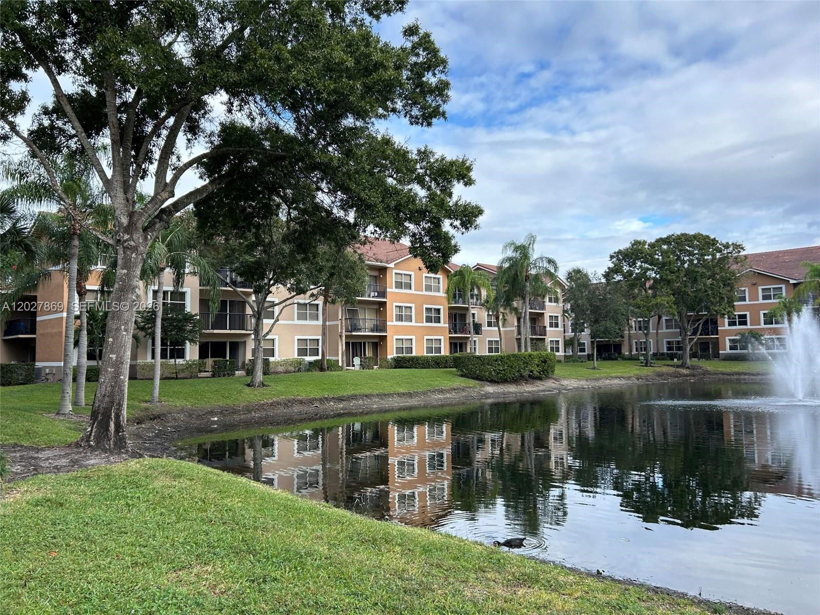 8761 Wiles Road, Unit 206 Coral Springs, FL 33067 - Photo 25 of 26 a view of a lake with a house in the background