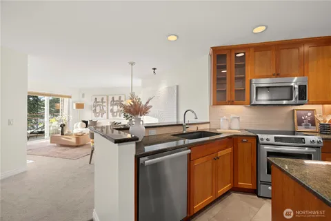 a kitchen with stainless steel appliances granite countertop a sink stove and cabinets