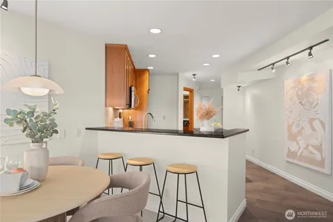 a kitchen with stainless steel appliances granite countertop a table chairs and a refrigerator