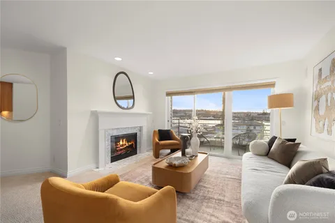 a living room with furniture fireplace and a large window