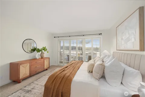 a bedroom with a bed and a large window