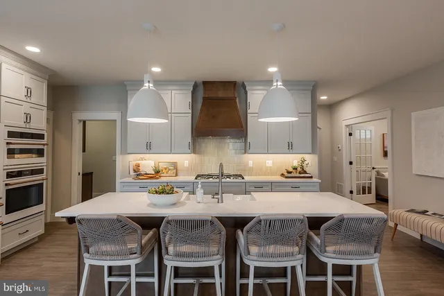 a kitchen with stainless steel appliances a dining table and chairs