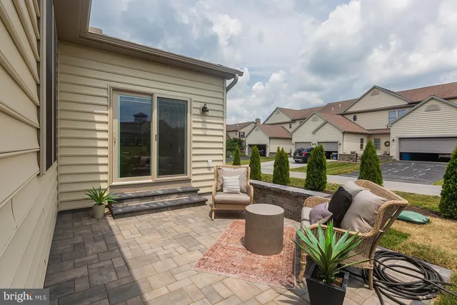 a view of a patio with couches table and chairs and potted plants