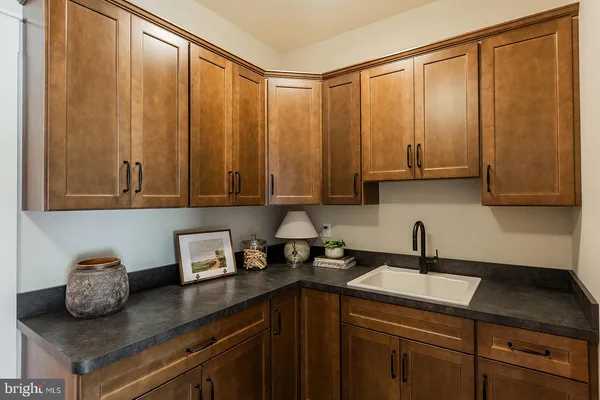a kitchen with stainless steel appliances granite countertop a sink window and cabinets