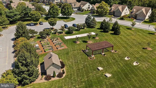 an aerial view of a house with outdoor space lake and trees all around