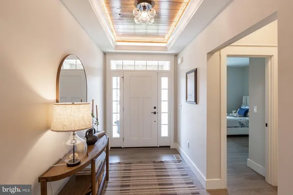 a view of a hallway with wooden floor and furniture