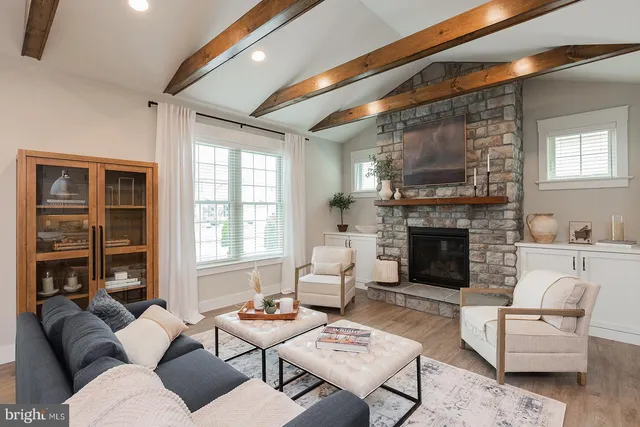 a living room with furniture a fireplace and a large window