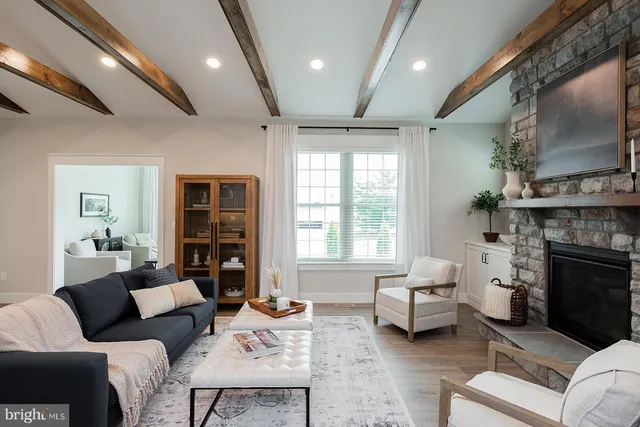 a living room with furniture a fireplace and a large window