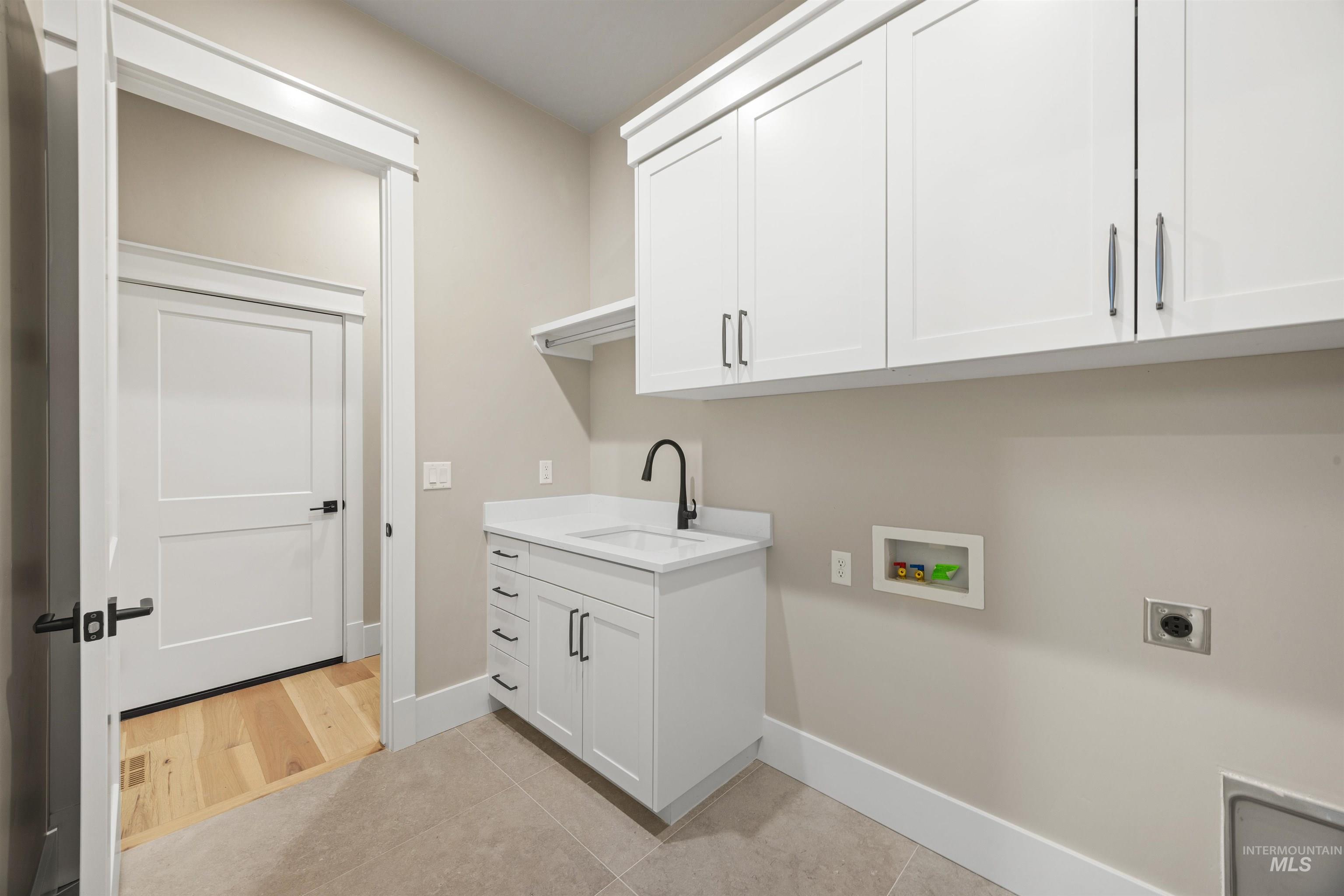 934 East Escalation Street Meridian, ID 83642 - Photo 18 of 50 Laundry area featuring cabinet space, light tile patterned floors, hookup for a washing machine, and hookup for an electric dryer