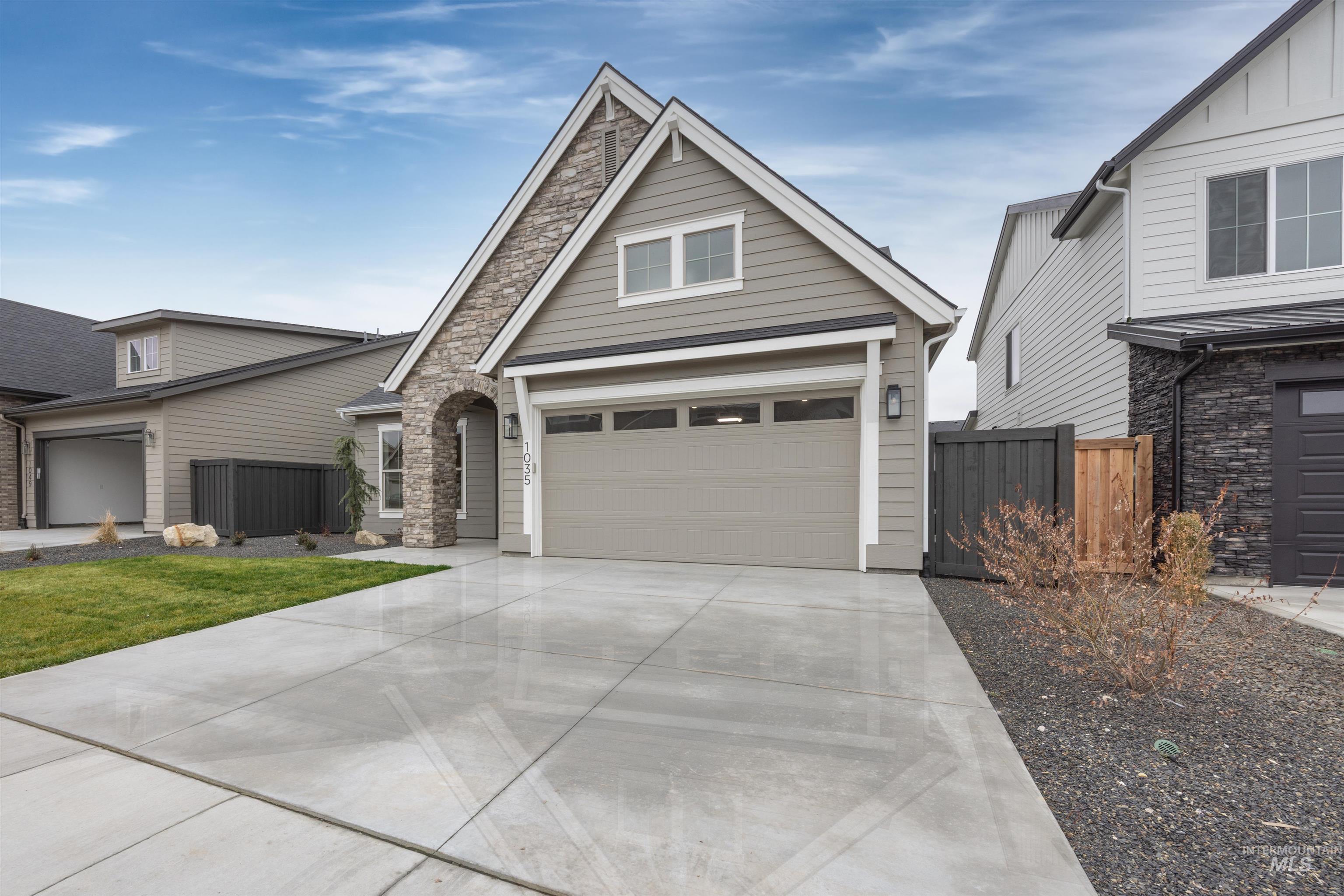 934 East Escalation Street Meridian, ID 83642 - Photo 2 of 50 View of front of home with driveway, stone siding, and a garage