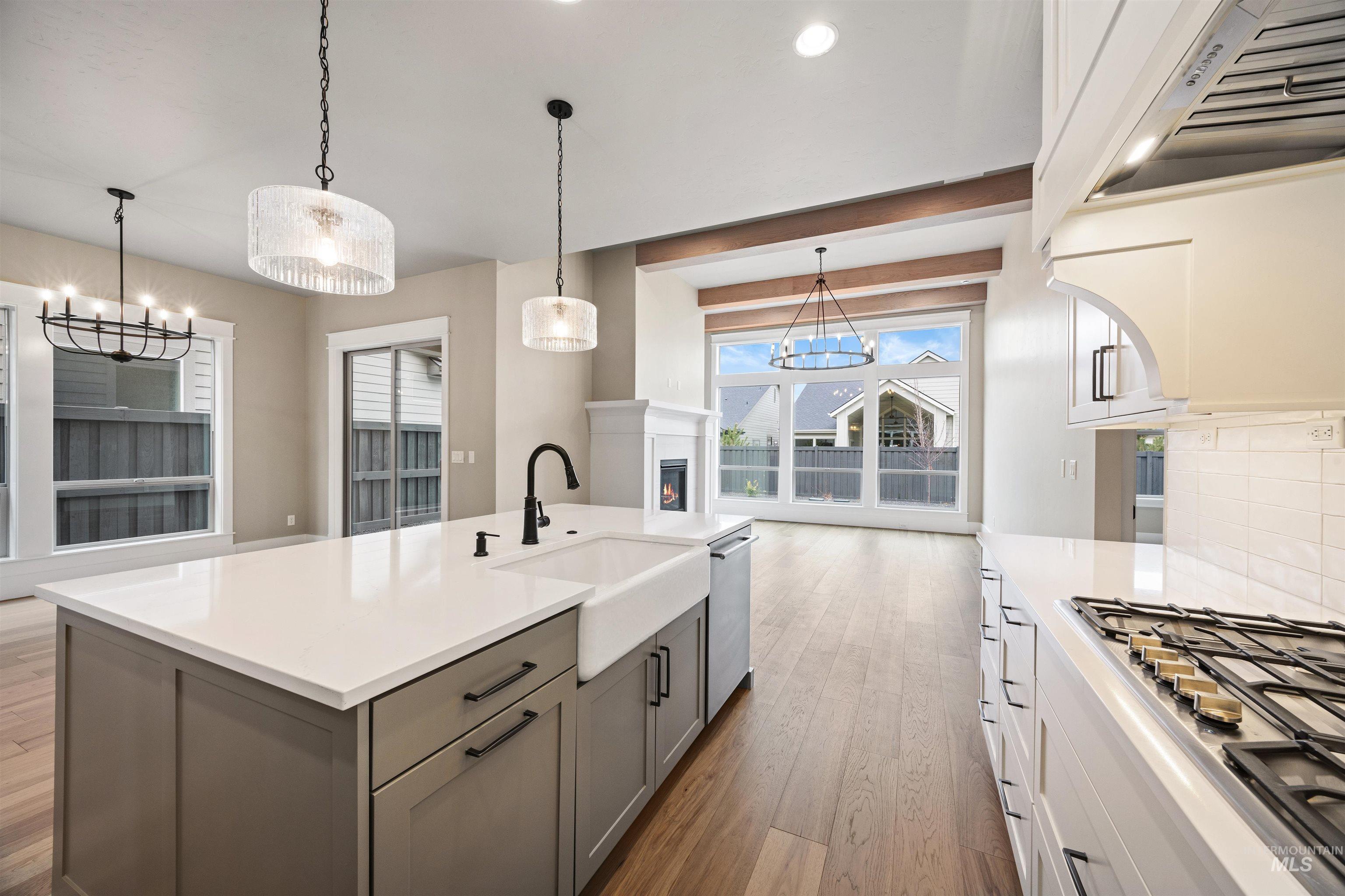 934 East Escalation Street Meridian, ID 83642 - Photo 32 of 50 Kitchen featuring two tone cabinetry, hanging lights, stainless steel appliances, dark wood-style flooring, and extractor fan