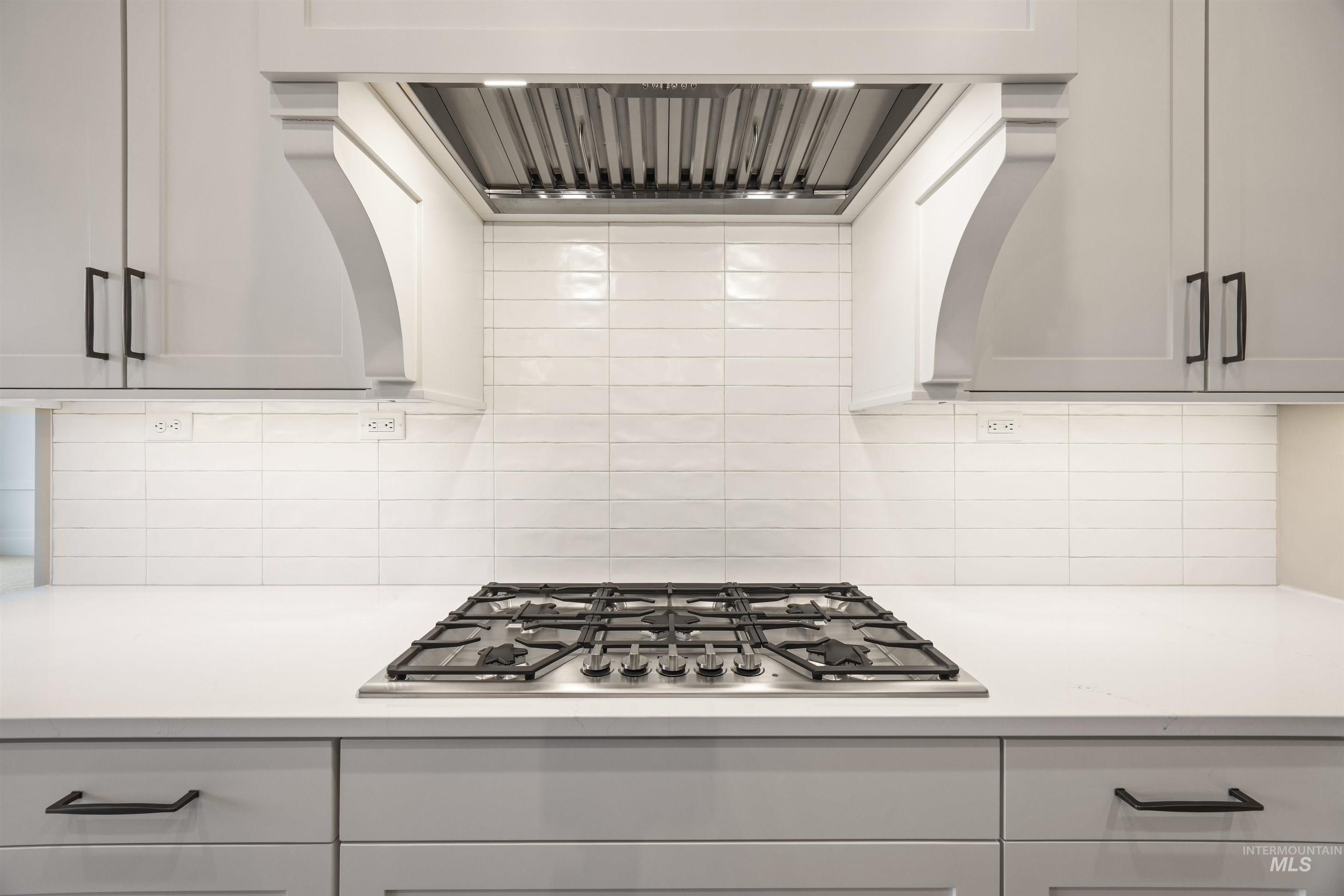 934 East Escalation Street Meridian, ID 83642 - Photo 35 of 50 Kitchen featuring extractor fan, stainless steel gas cooktop, tasteful backsplash, and light stone countertops