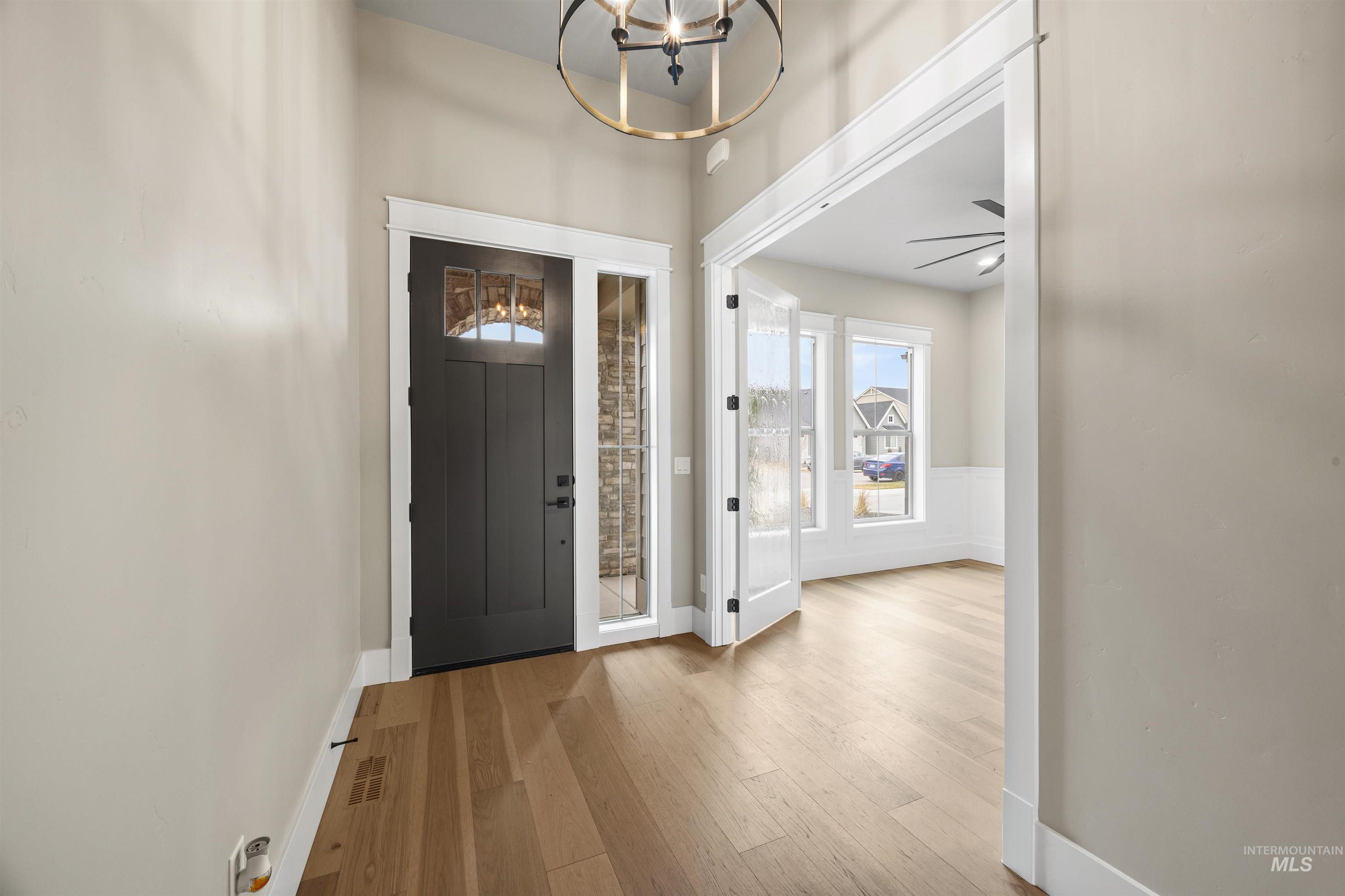934 East Escalation Street Meridian, ID 83642 - Photo 4 of 50 Entrance foyer with light wood finished floors, suspended lighting, and a ceiling fan