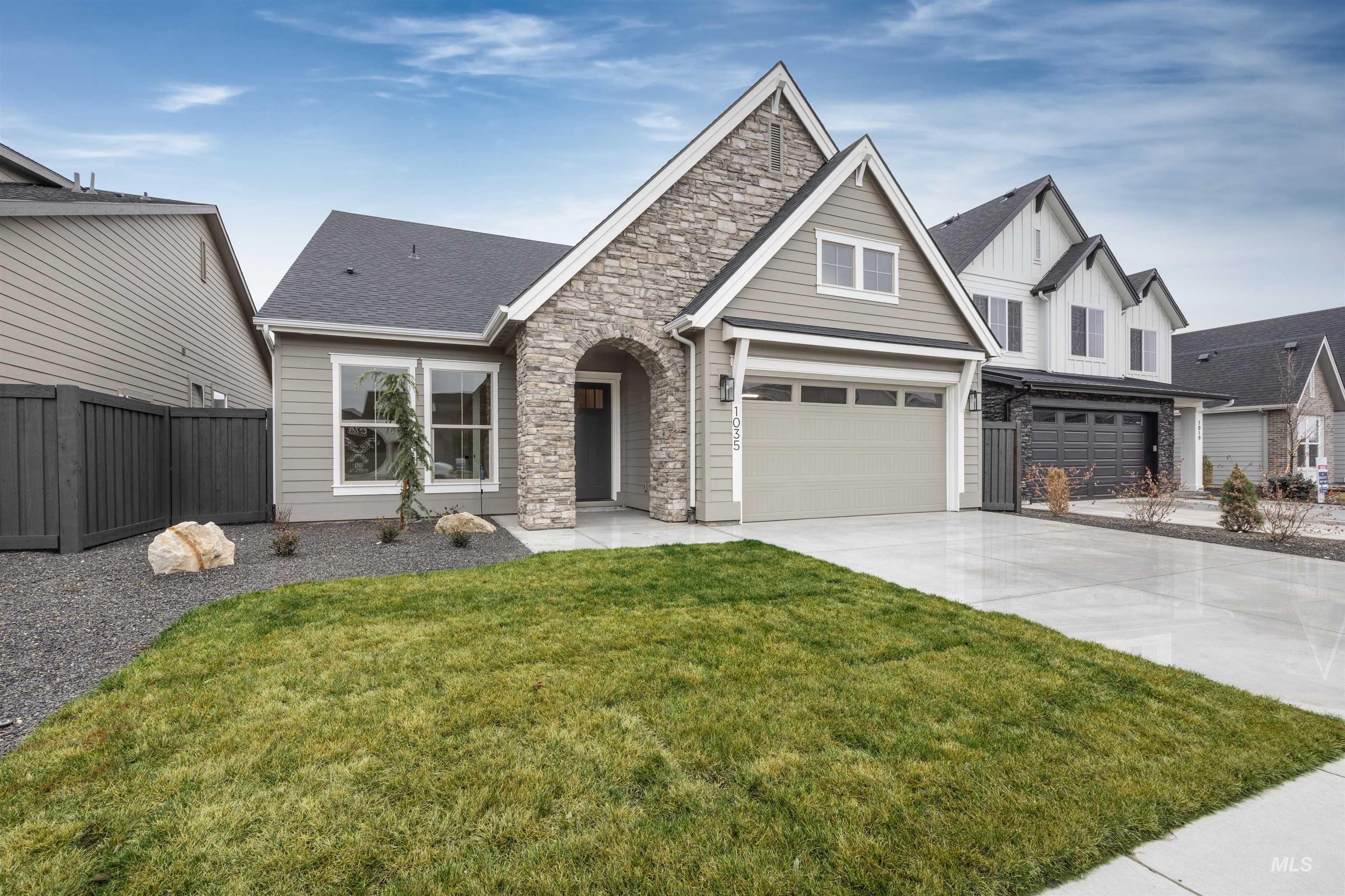 934 East Escalation Street Meridian, ID 83642 - Photo 49 of 50 View of front of home featuring stone siding, concrete driveway, board and batten siding, and an attached garage