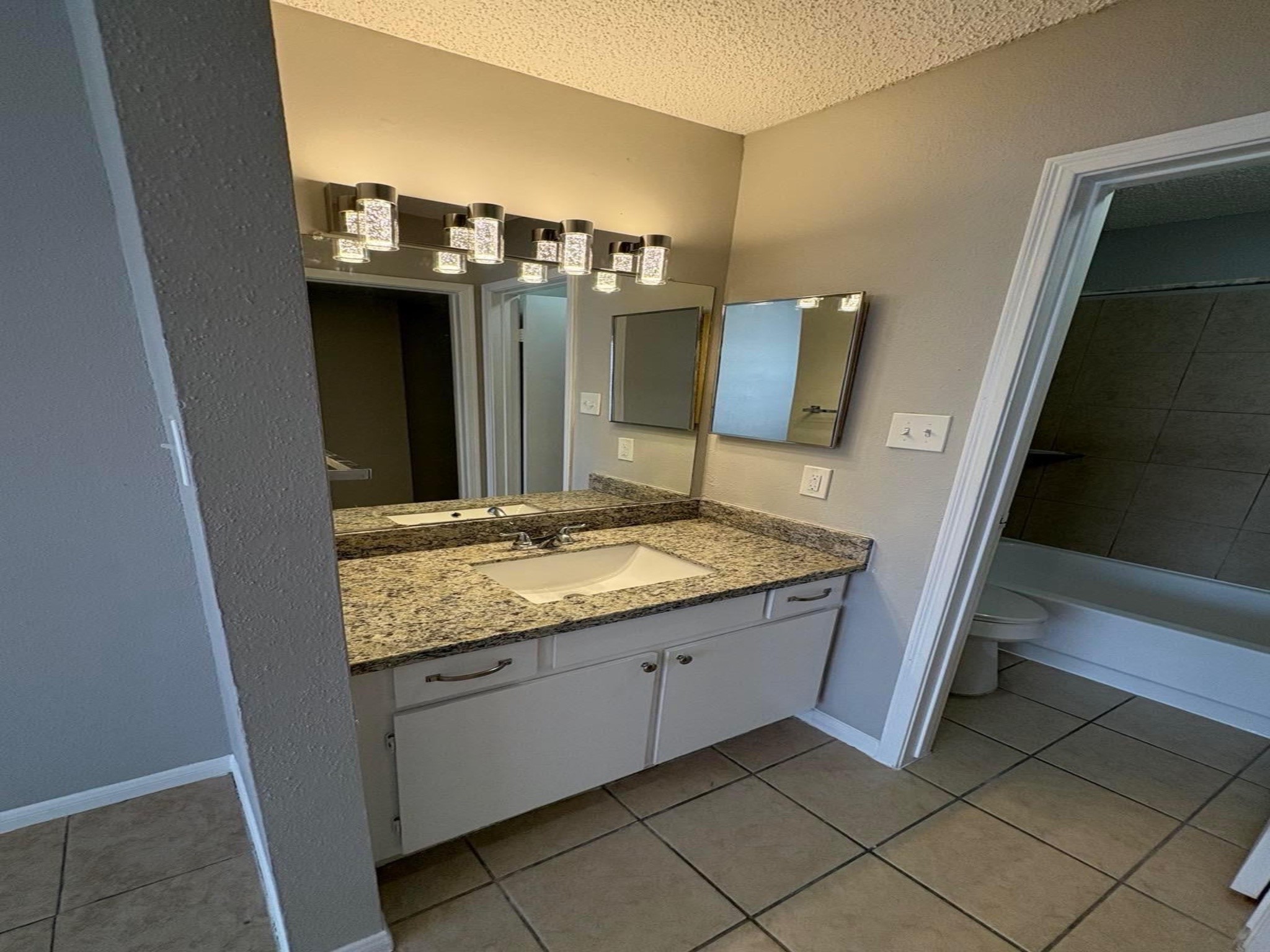 10101 South Gessner Road, Unit 515 Houston, TX 77071 - Photo 9 of 10 a bathroom with a granite countertop sink and a mirror