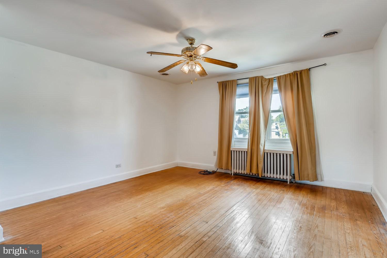 7103 Harford Road Baltimore, MD 21234 - Photo 14 of 27 an empty room with wooden floor fan and windows