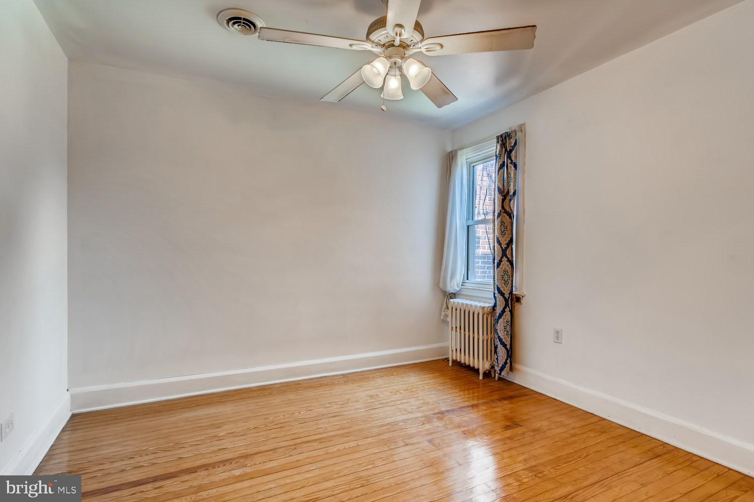 7103 Harford Road Baltimore, MD 21234 - Photo 16 of 27 an empty room with wooden floor fan and windows