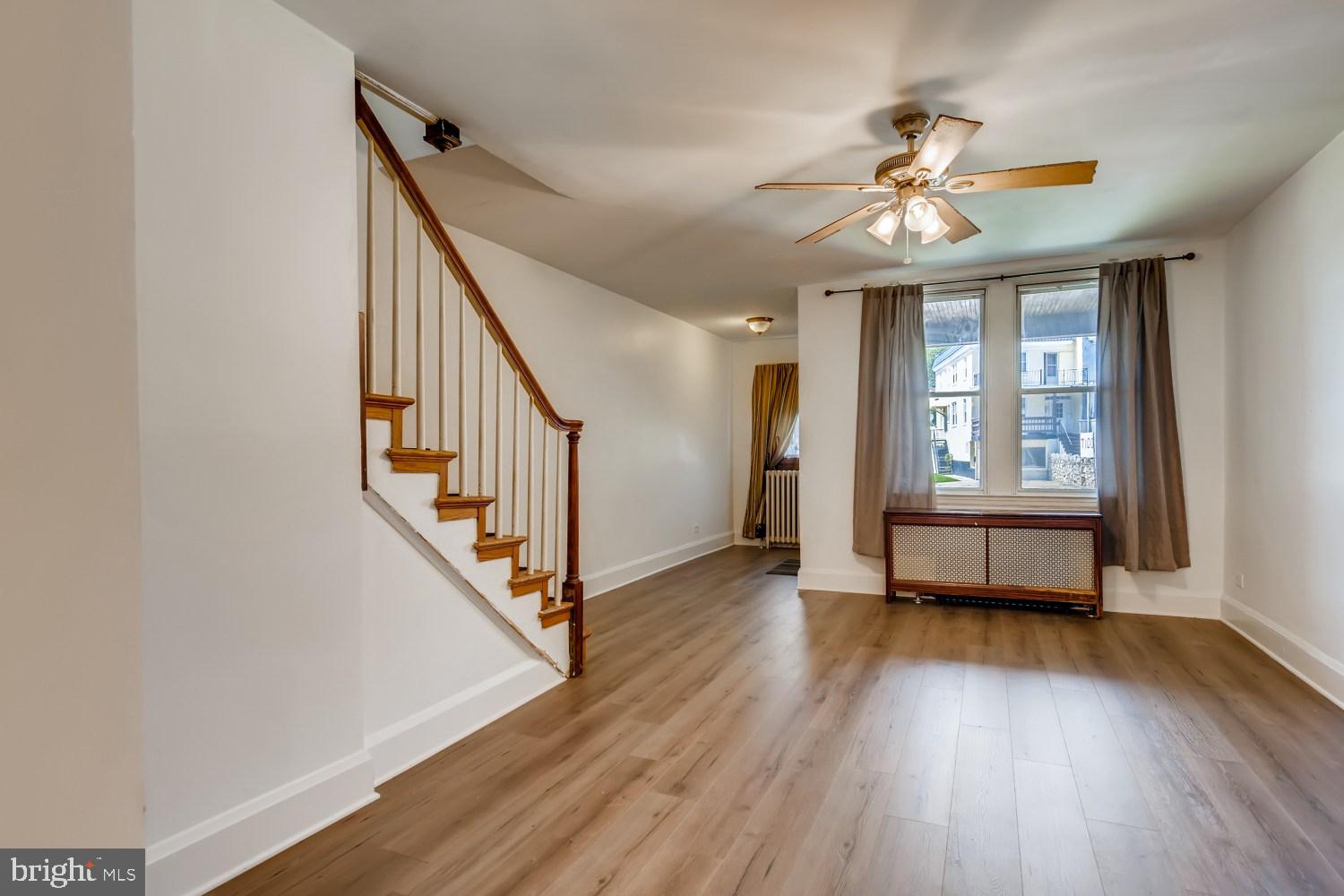 7103 Harford Road Baltimore, MD 21234 - Photo 6 of 27 a view of an empty room with wooden floor and a window