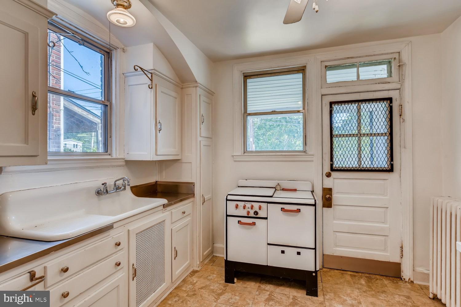 7103 Harford Road Baltimore, MD 21234 - Photo 10 of 27 a kitchen with white cabinets and window
