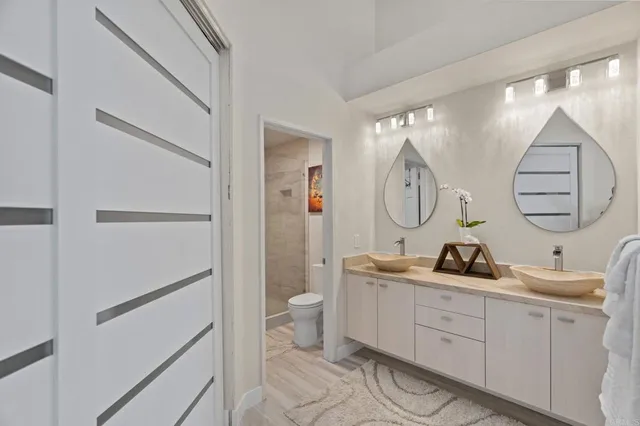 a bathroom with a double vanity sink mirror and toilet