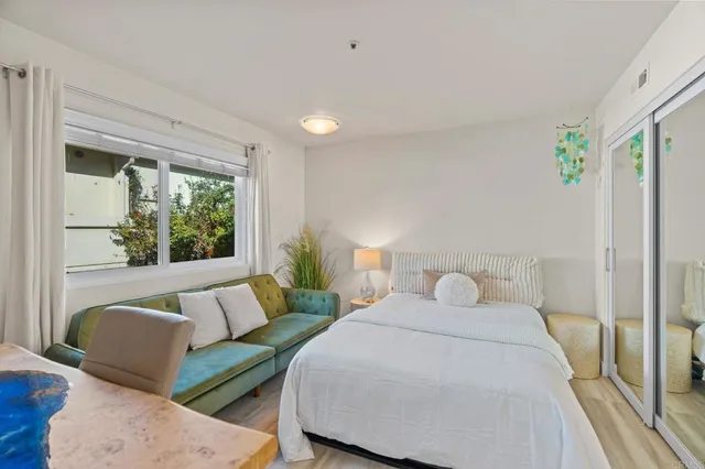 a bedroom with furniture and a large window