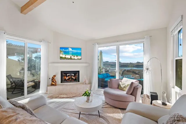 a living room with furniture a floor to ceiling window and a flat screen tv