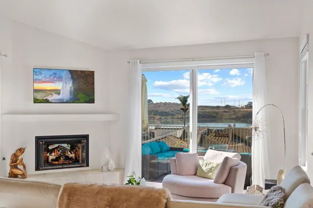 a living room with furniture a floor to ceiling window and a fireplace