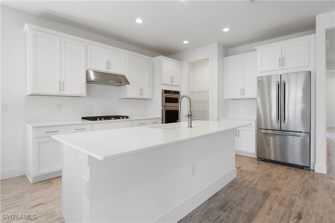 16245 Wax Myrtle Street Punta Gorda, FL 33982 - Photo 12 of 22 a kitchen with stainless steel appliances a refrigerator sink and microwave
