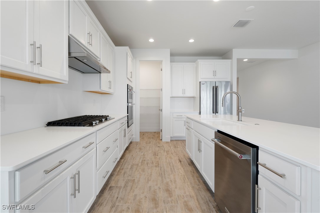 16245 Wax Myrtle Street Punta Gorda, FL 33982 - Photo 13 of 22 a kitchen with stainless steel appliances sink stove refrigerator and cabinets
