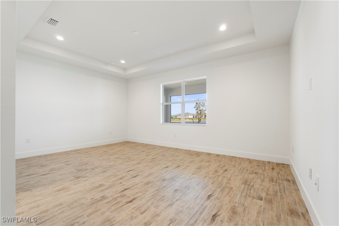 16245 Wax Myrtle Street Punta Gorda, FL 33982 - Photo 15 of 22 an empty room with wooden floor and windows