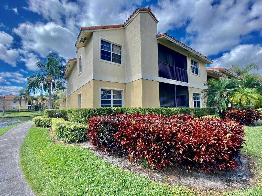 1247 Southwest 46th Avenue, Unit 1301 Pompano Beach, FL 33069 - Photo 1 of 22 a front view of a house with a garden