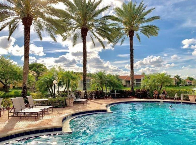 1247 Southwest 46th Avenue, Unit 1301 Pompano Beach, FL 33069 - Photo 20 of 22 a view of swimming pool with a table and chairs