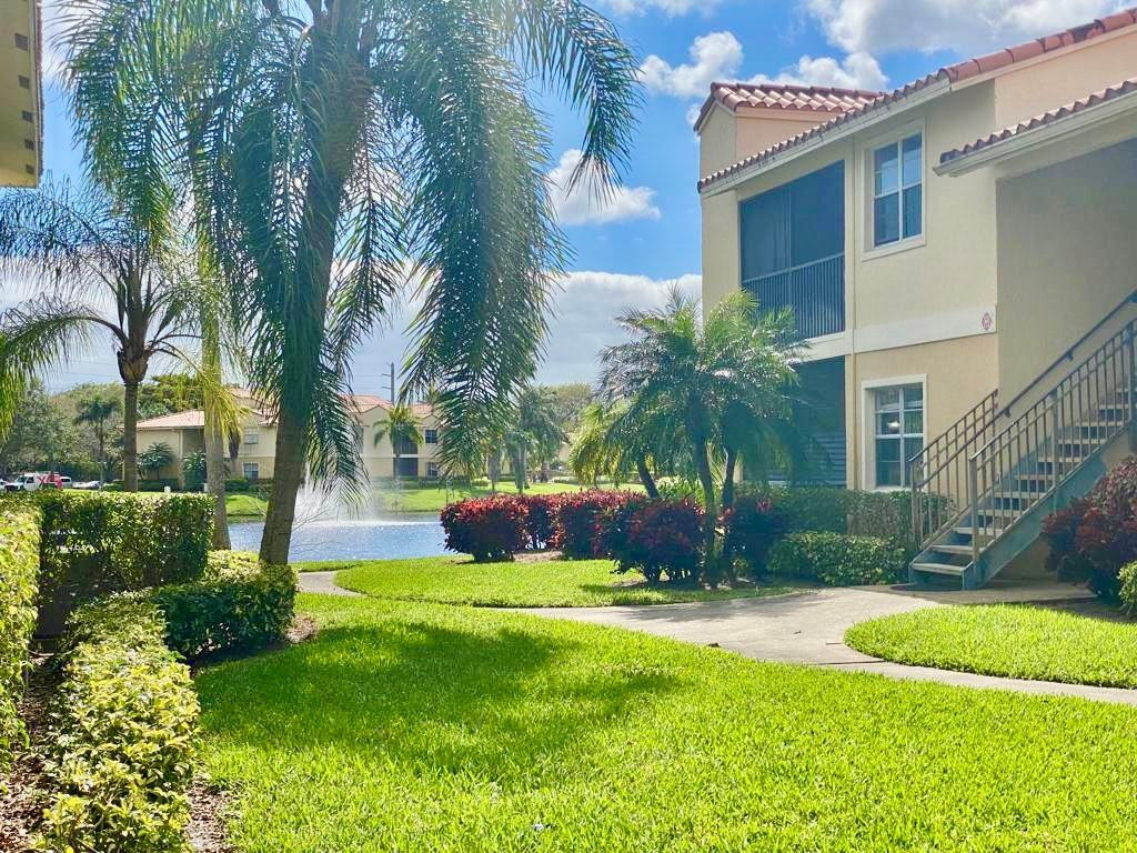1247 Southwest 46th Avenue, Unit 1301 Pompano Beach, FL 33069 - Photo 2 of 22 a view of a house with a yard and a garden
