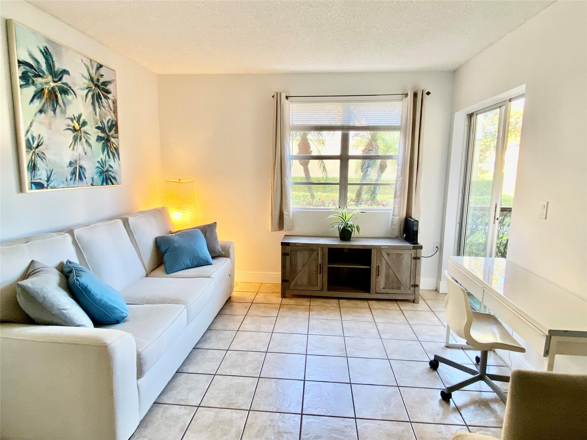 1247 Southwest 46th Avenue, Unit 1301 Pompano Beach, FL 33069 - Photo 3 of 22 a living room with furniture and a window