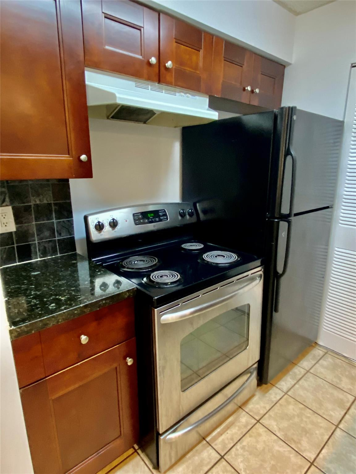 1247 Southwest 46th Avenue, Unit 1301 Pompano Beach, FL 33069 - Photo 8 of 22 a stove top oven sitting inside of a kitchen