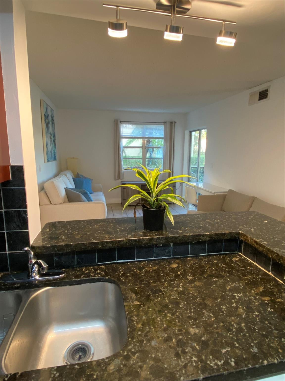 1247 Southwest 46th Avenue, Unit 1301 Pompano Beach, FL 33069 - Photo 9 of 22 a bathroom with a granite countertop sink a bathtub and window