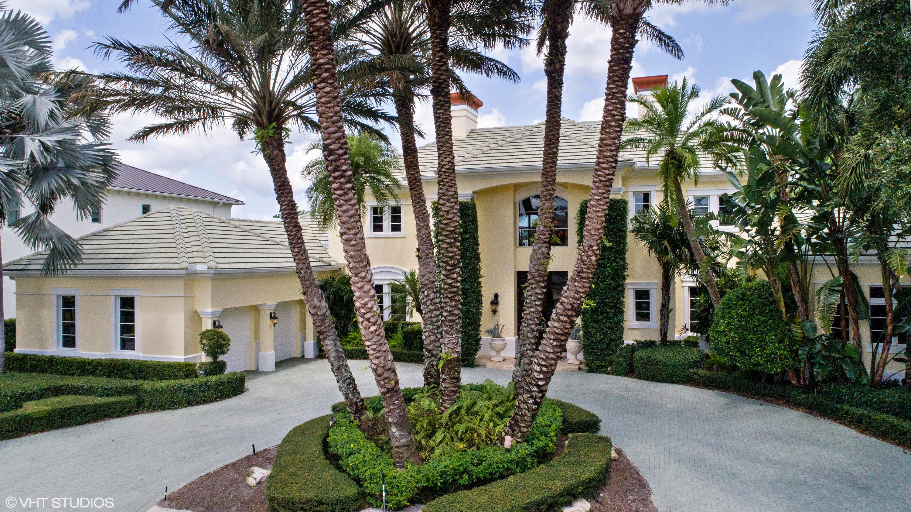 a front view of a house with garden and trees