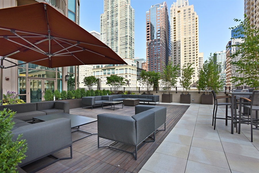 21 East Huron Street, Unit 1407 Chicago, IL 60611 - Photo 19 of 23 a view of a patio with couches and table under an umbrella