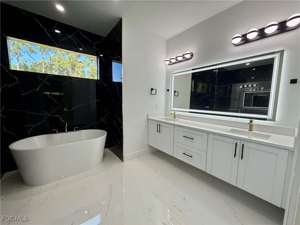 2909 10th Street West Lehigh Acres, FL 33971 - Photo 15 of 31 a bathroom with a sink a bathtub and mirror