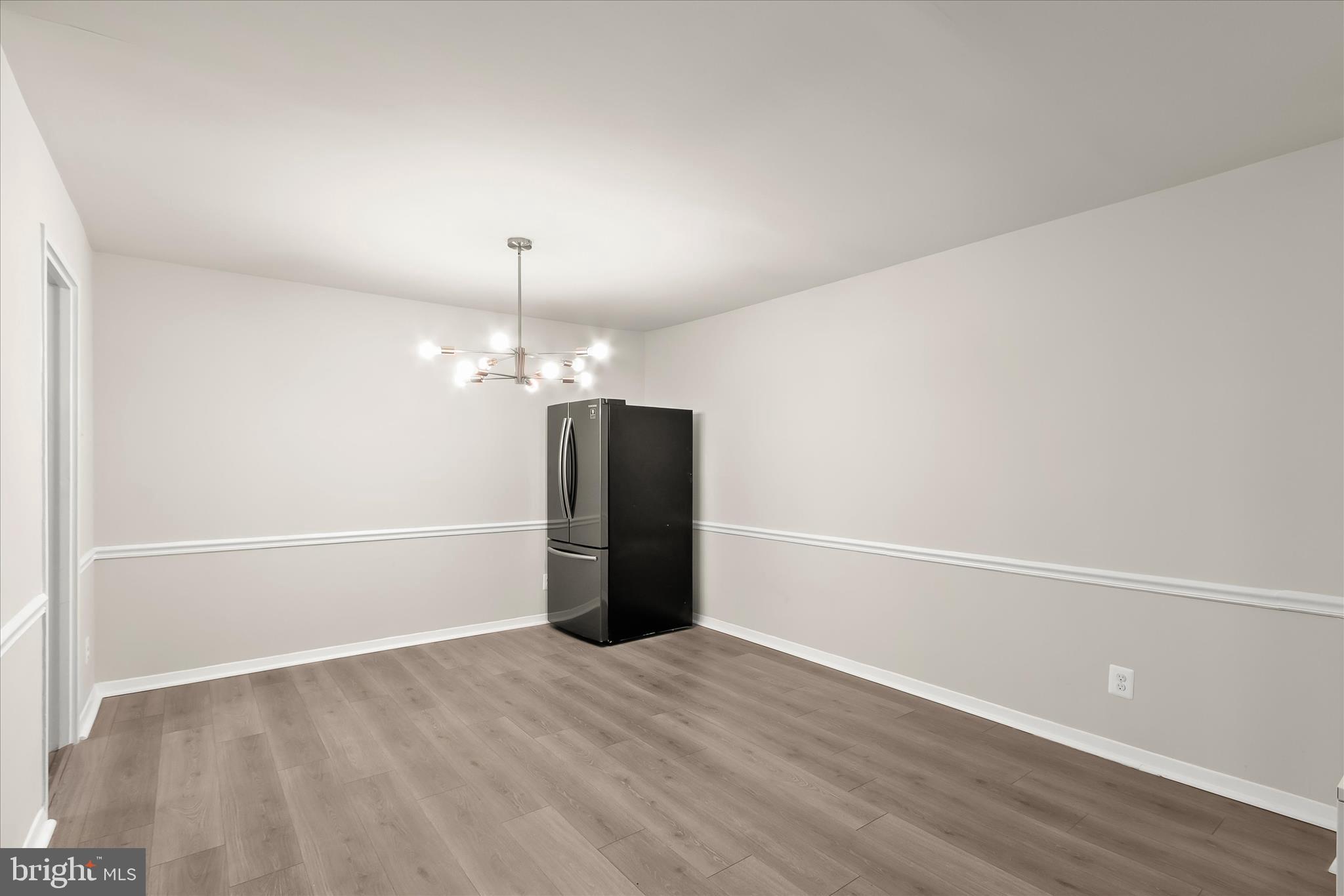 1900 Lyttonsville Road, Unit 216 Silver Spring, MD 20910 - Photo 13 of 36 a view of an empty room with wooden floor and a window