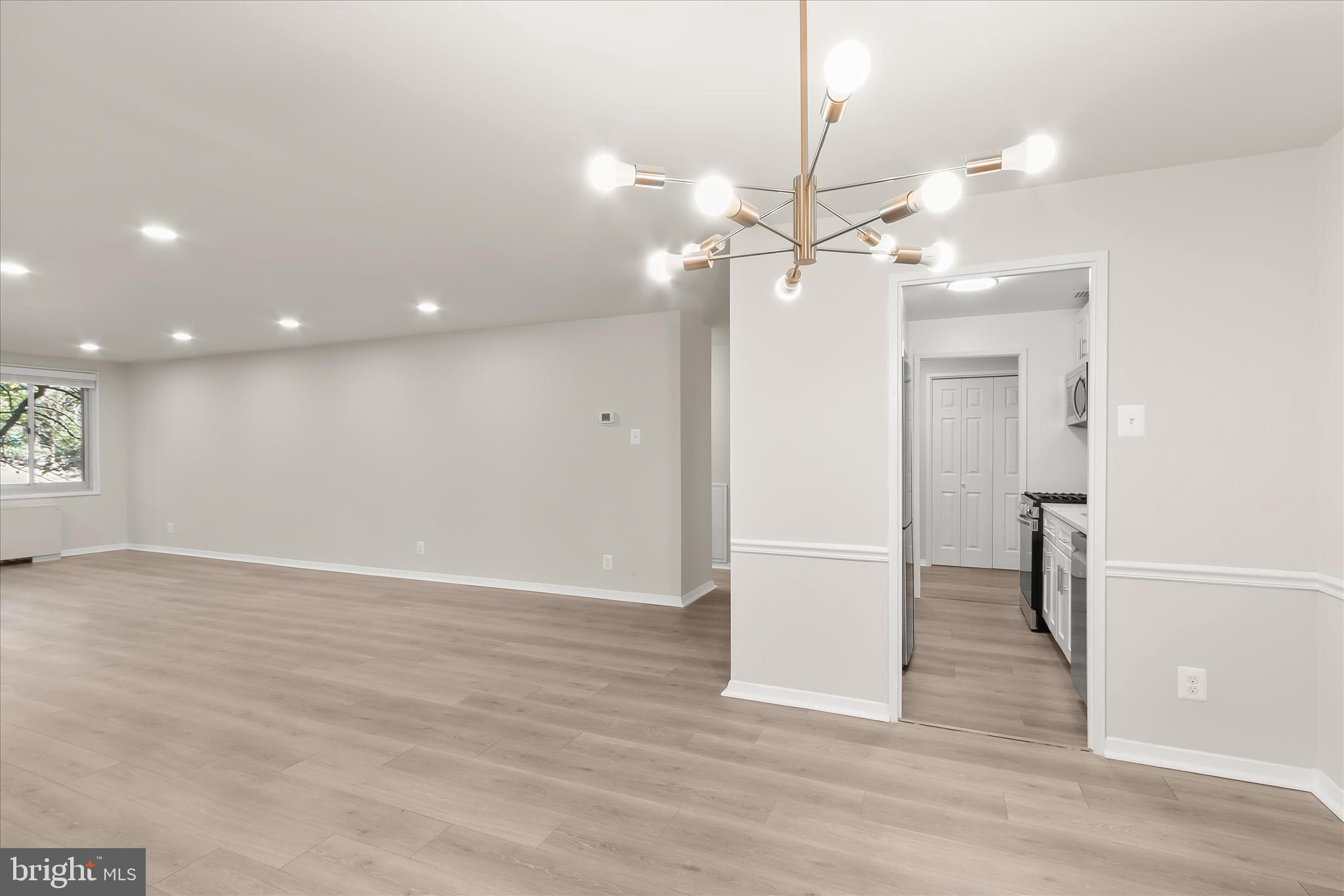 1900 Lyttonsville Road, Unit 216 Silver Spring, MD 20910 - Photo 14 of 36 an empty room with wooden floor and ceiling fan